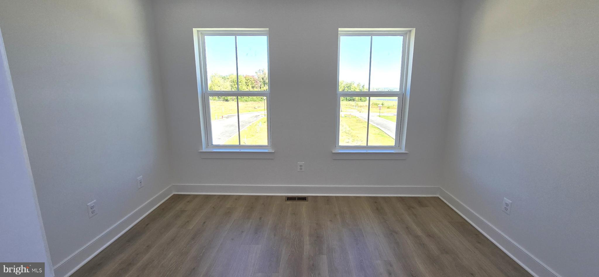1726 Blacksmith Way Frederick, MD 21702 - Photo 54 of 64 an empty room with wooden floor and windows