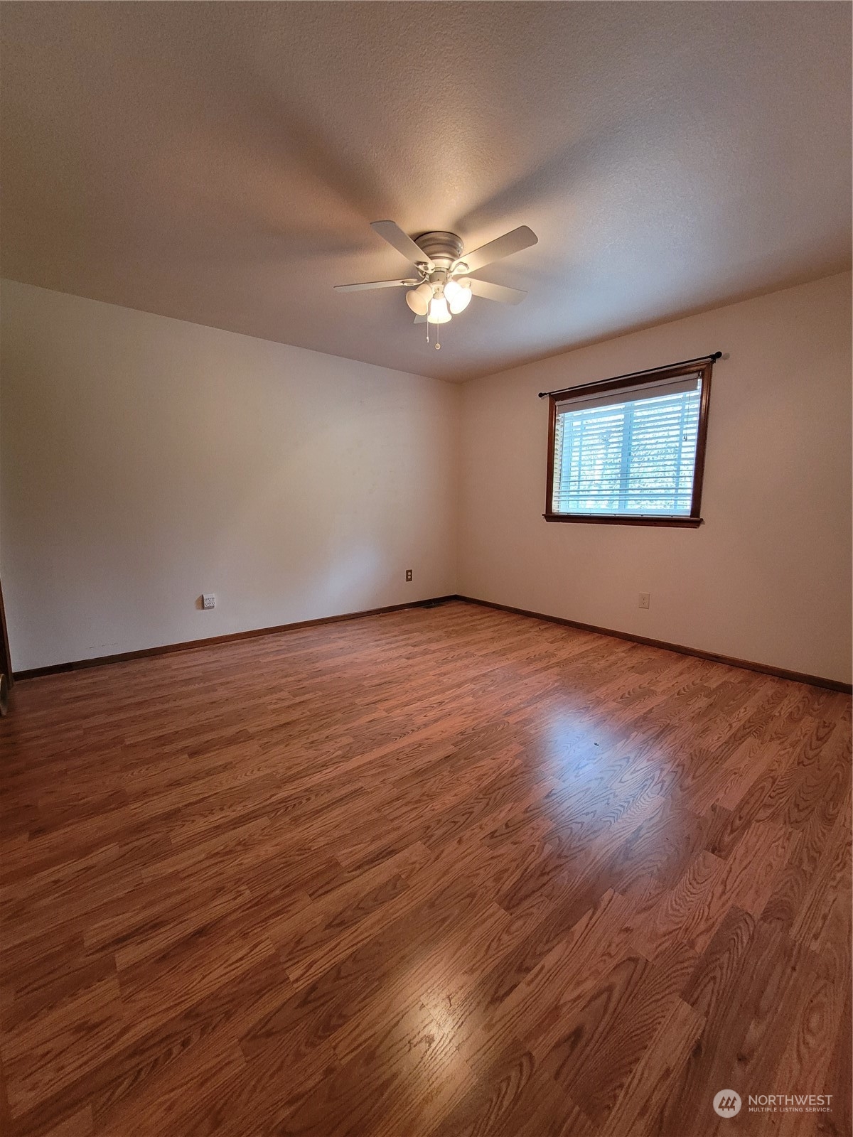2517 Walnut Loop Northwest Olympia, WA 98502 - Photo 30 of 38 an empty room with wooden floor ceiling fan and windows