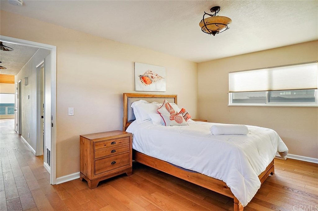 3498 Studio Drive Cayucos, CA 93430 - Photo 21 of 36 a bedroom with a bed and wooden floor