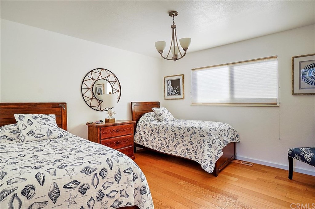 3498 Studio Drive Cayucos, CA 93430 - Photo 24 of 36 a bedroom with two bed and a large clock on the dresser