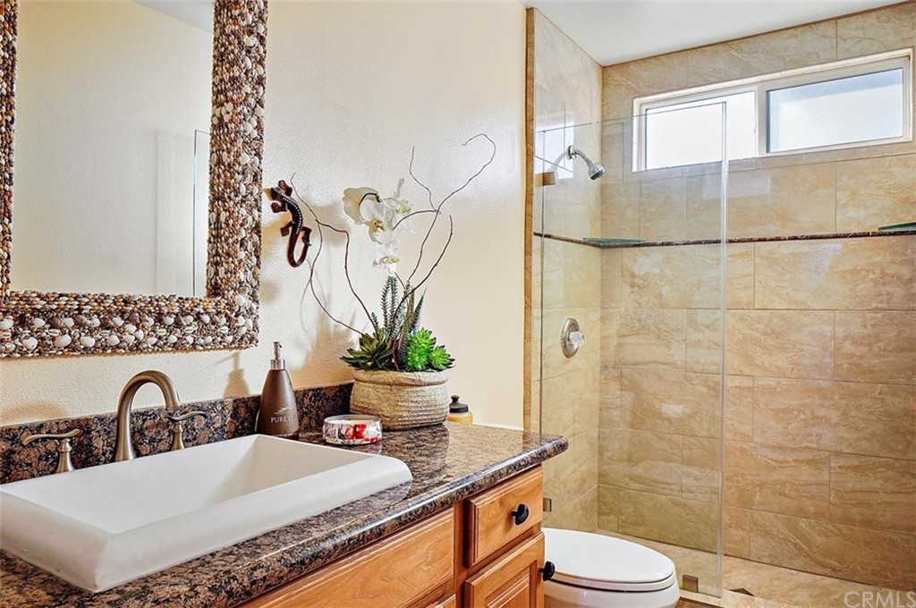 3498 Studio Drive Cayucos, CA 93430 - Photo 25 of 36 a bathroom with a granite countertop sink and a mirror