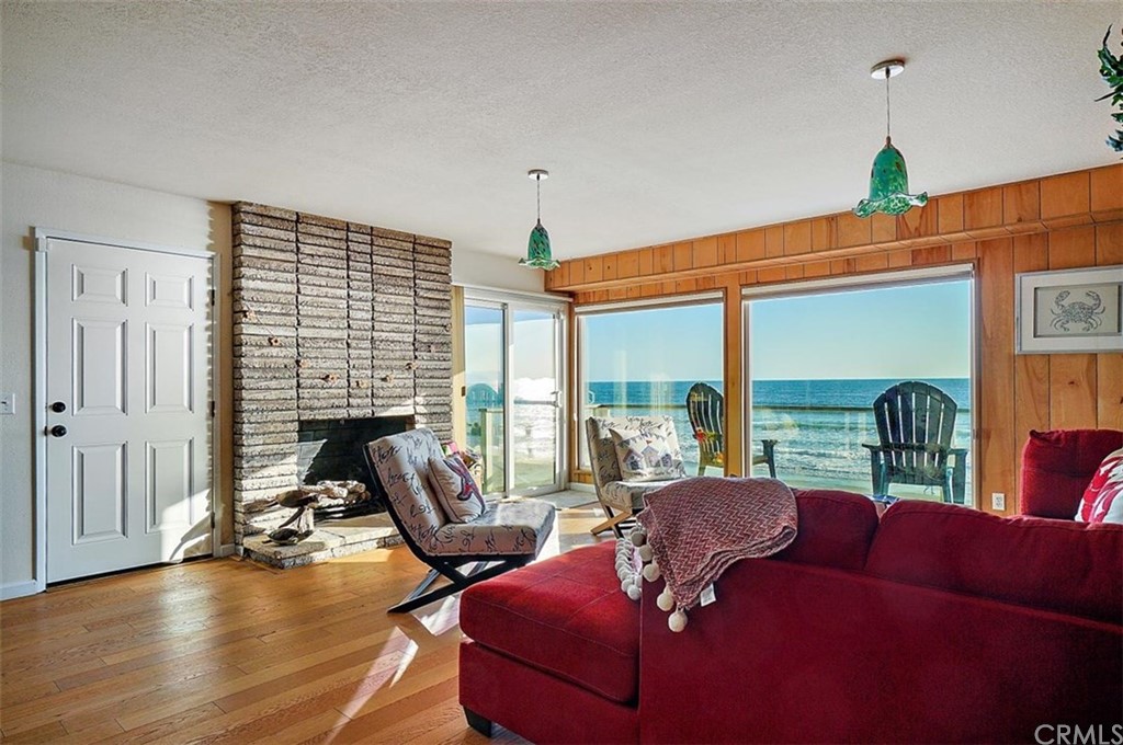 3498 Studio Drive Cayucos, CA 93430 - Photo 29 of 36 a living room with furniture floor to ceiling window and wooden floor