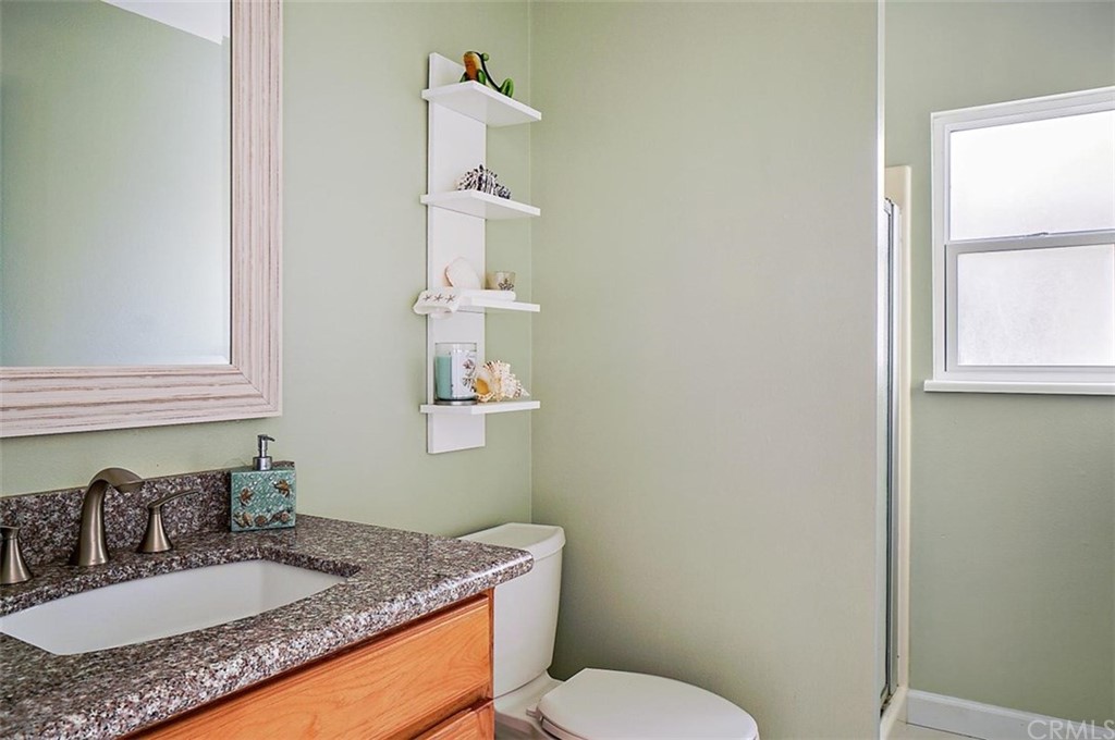 3498 Studio Drive Cayucos, CA 93430 - Photo 31 of 36 a bathroom with a granite countertop sink toilet and mirror