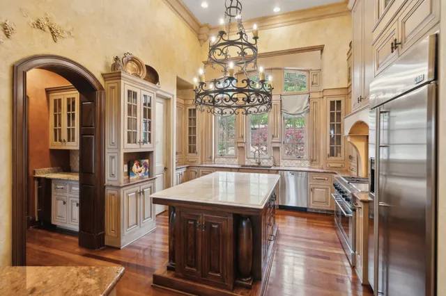 a bedroom with a large bed and a chandelier