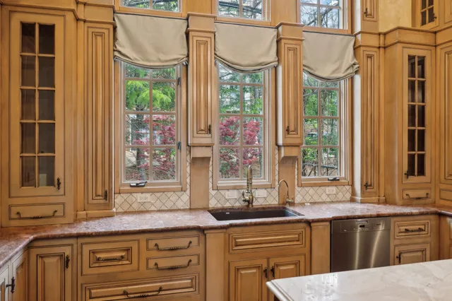 a bathroom with a granite countertop shower a mirror and a sink