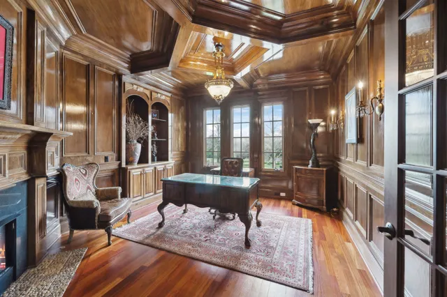 a spacious bedroom with a bed a mirror and a flat tv screen on a dresser