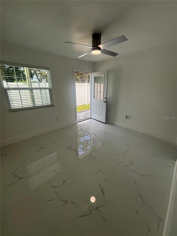 1524 Windermere Road, Unit A Winter Garden, FL 34787 - Photo 2 of 9 an empty room with windows and ceiling fan