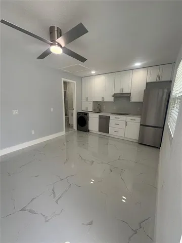 a view of kitchen with stainless steel appliances refrigerator and cabinets