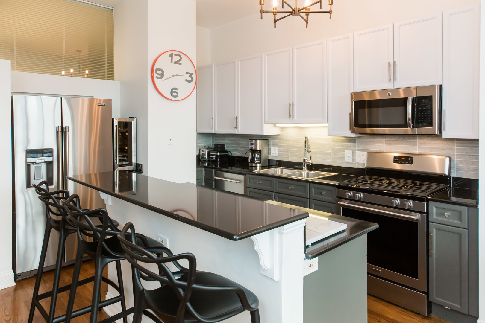 1201 West Adams Street, Unit 705 Chicago, IL 60607 - Photo 11 of 30 a kitchen with stainless steel appliances granite countertop a sink a stove and a microwave