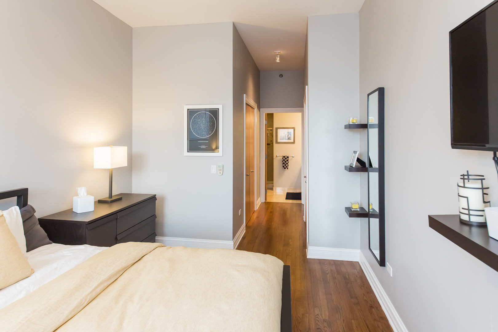 1201 West Adams Street, Unit 705 Chicago, IL 60607 - Photo 16 of 30 a bedroom with a bed and a flat tv screen on a dresser
