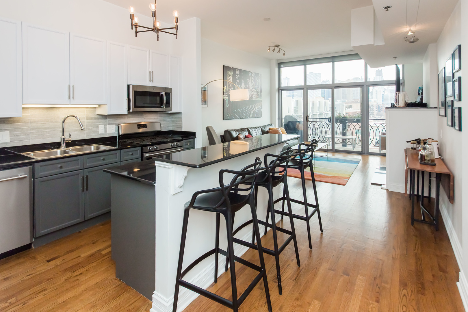 1201 West Adams Street, Unit 705 Chicago, IL 60607 - Photo 9 of 30 a kitchen with stainless steel appliances granite countertop wooden floor a large window a sink and chairs
