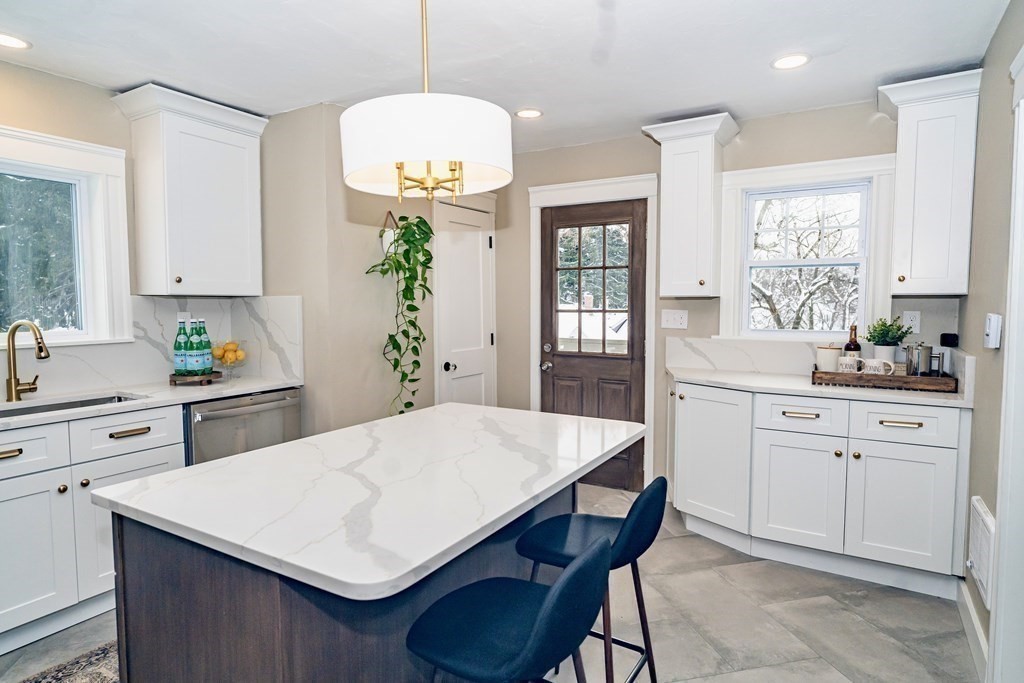 65 Hadwen Road Worcester, MA 01602 - Photo 16 of 38 a kitchen with a table a sink cabinets and wooden floor