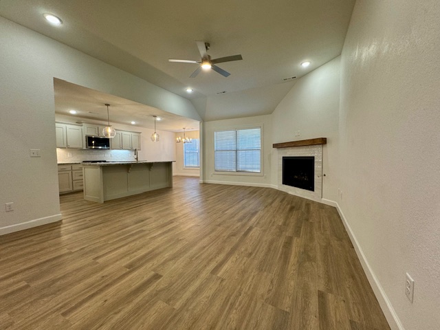 2250 Hunter Drive Pea Ridge, AR 72751 - Photo 5 of 21 Open concept living space featuring vaulted ceilings, wood-finish flooring, a fireplace with a wood mantel, recessed lighting, and a ceiling fan
