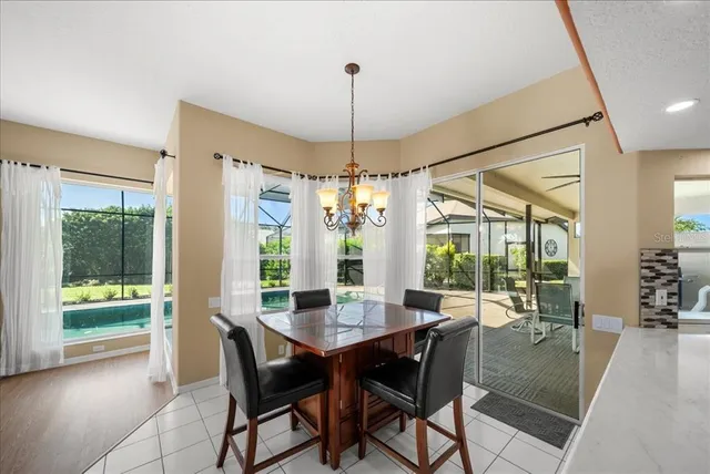 a view of a dining room and livingroom with furniture wooden floor a chandelier