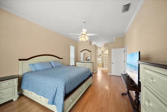a bedroom with a large bed and a chandelier