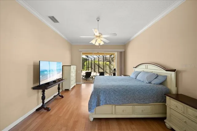 a bedroom with a bed and a flat tv screen on dresser