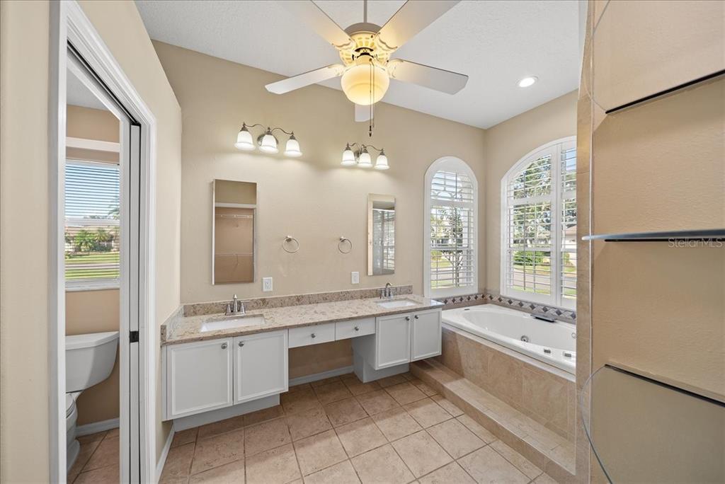 4321 Presidential Ave Circle East Bradenton, FL 34203 - Photo 27 of 49 a bathroom with a granite countertop sink a large mirror and a bathtub with shower