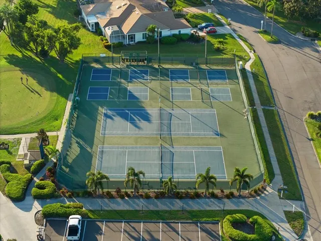 an aerial view of a house with outdoor space and trees all around