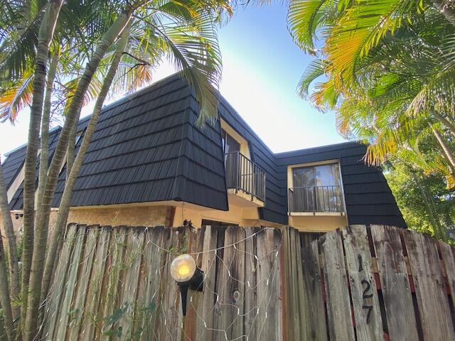 127 Woodland Road Palm Springs, FL 33461 - Photo 2 of 11 a view of a house with wooden fence
