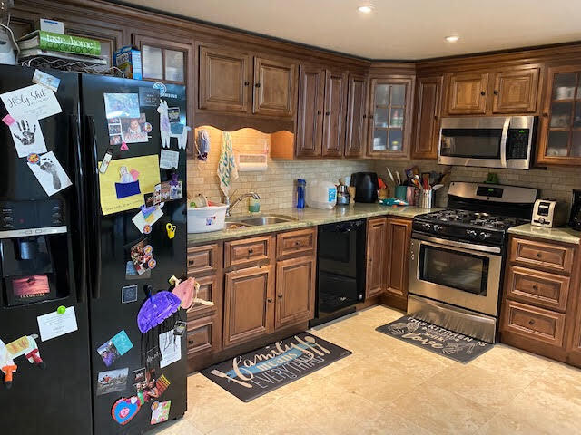 127 Woodland Road Palm Springs, FL 33461 - Photo 6 of 11 a kitchen with stainless steel appliances granite countertop a stove a sink and a refrigerator