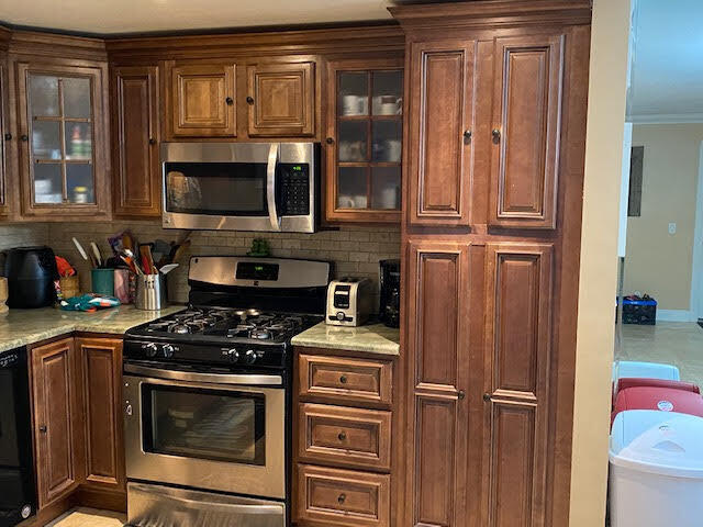 127 Woodland Road Palm Springs, FL 33461 - Photo 7 of 11 a kitchen with wooden cabinets and a stove top oven