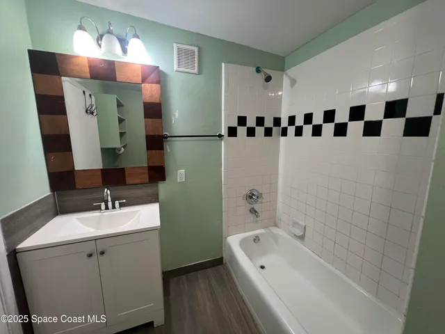a bathroom with a bathtub sink and mirror
