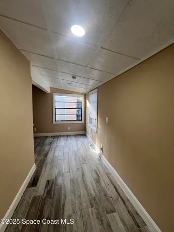 a view of empty room with wooden floor