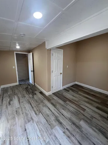 a view of a room with wooden floor