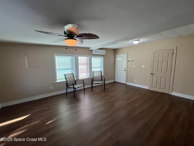 a view of a room with wooden floor and windows