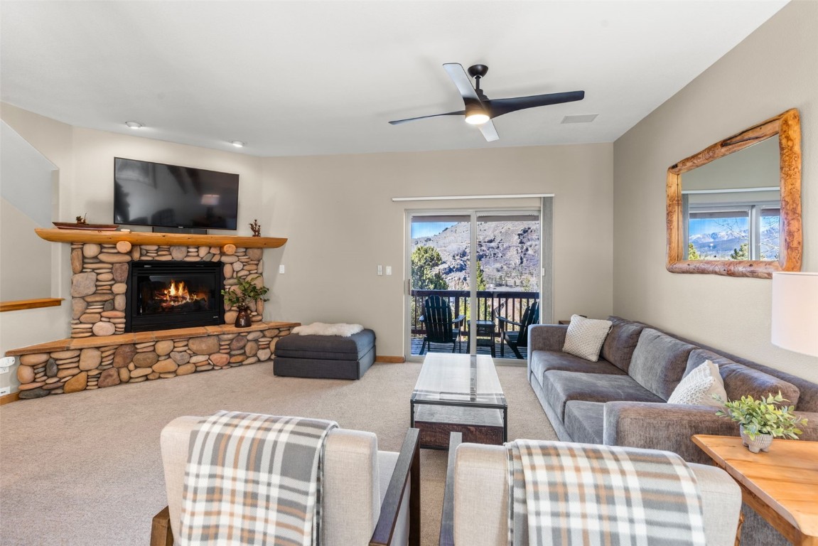 142 Lookout Ridge Drive Dillon, CO 80435 - Photo 1 of 39 Living room with a stone fireplace, carpet flooring, and ceiling fan