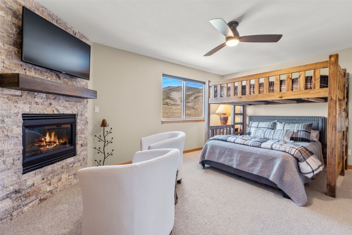 142 Lookout Ridge Drive Dillon, CO 80435 - Photo 23 of 39 Carpeted bedroom featuring ceiling fan and a fireplace