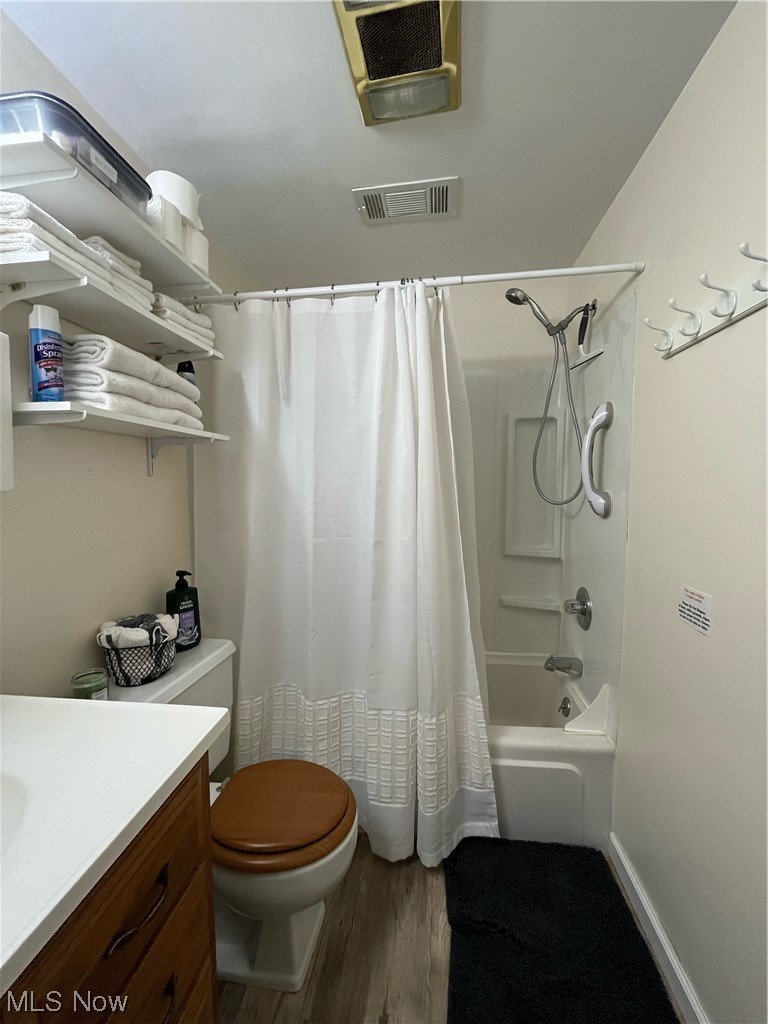 4972 West Fremont Road Port Clinton, OH 43452 - Photo 18 of 29 Full bathroom featuring vanity, shower / bath combination with curtain, hardwood / wood-style flooring, and toilet