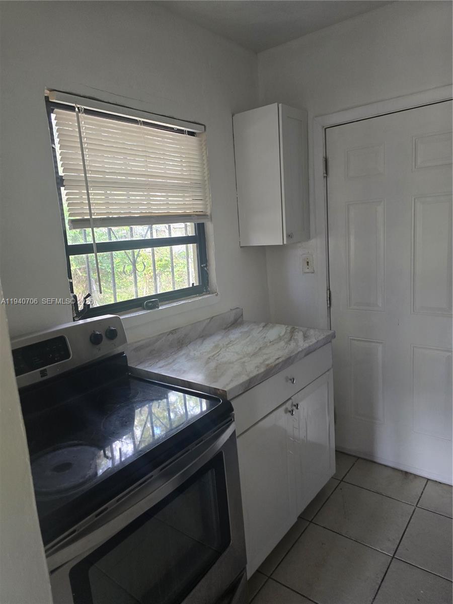 143 Northwest 69th Street, Unit 3 Miami, FL 33150 - Photo 4 of 7 a kitchen with a stove and a refrigerator