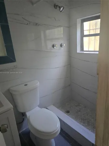 a bathroom with a toilet and a shower