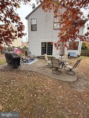 a view of a backyard with table and chairs couches and a fire pit