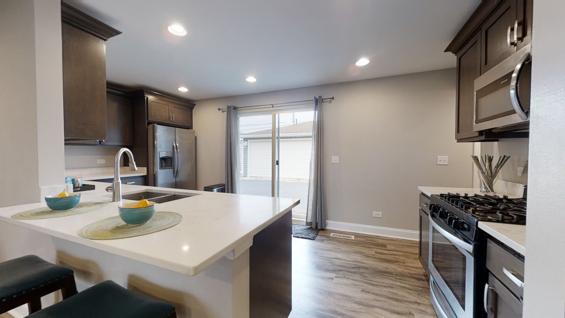 153 Queenswood Road Bolingbrook, IL 60440 - Photo 4 of 17 a kitchen with a sink a stove and chairs
