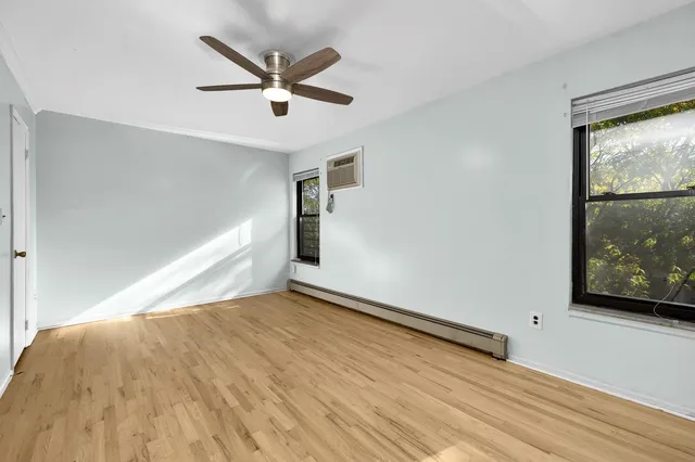 a view of a livingroom with wooden floor and a ceiling fan