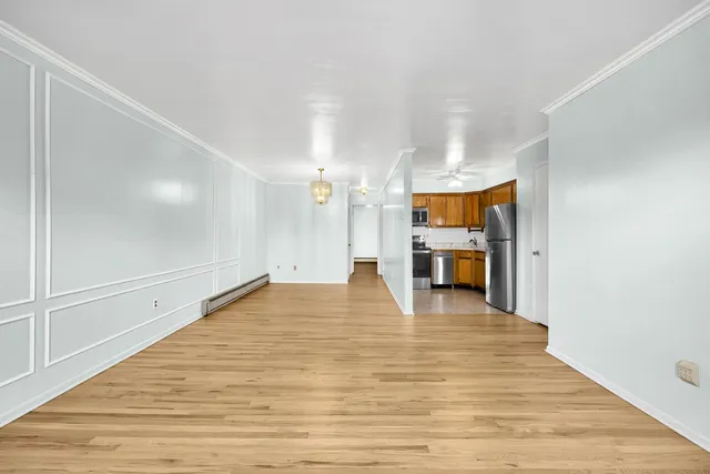 a view of empty room with wooden floor
