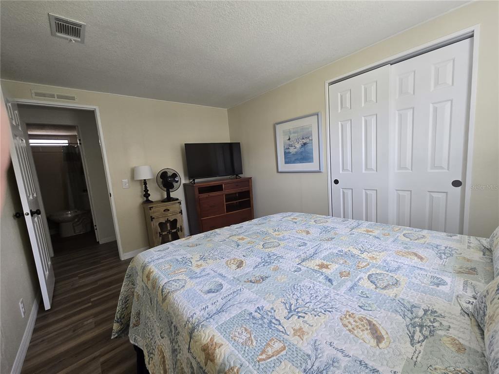 3935 Parway Road, Unit 1322 Zellwood, FL 32798 - Photo 21 of 28 a bedroom with a bed and a flat tv screen on dresser