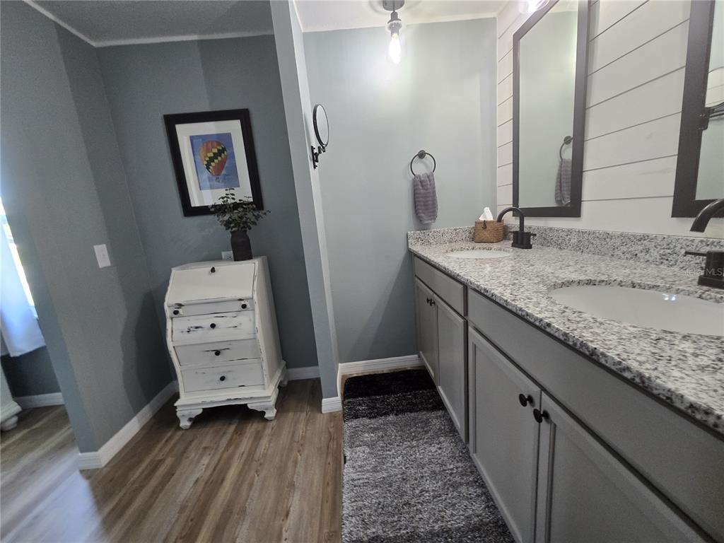 3935 Parway Road, Unit 1322 Zellwood, FL 32798 - Photo 23 of 28 a bathroom with a granite countertop sink and a mirror