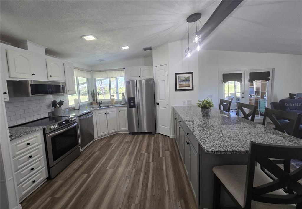 3935 Parway Road, Unit 1322 Zellwood, FL 32798 - Photo 8 of 28 a kitchen with stainless steel appliances granite countertop a stove refrigerator and cabinets