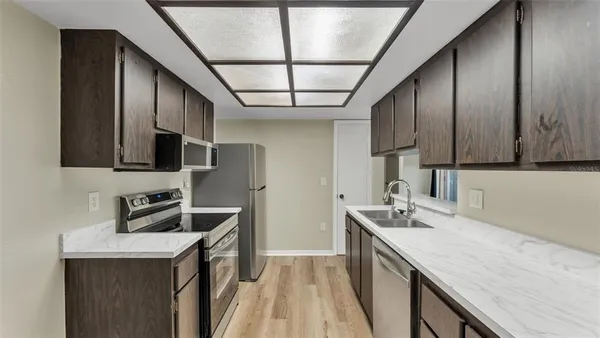 a kitchen with stainless steel appliances granite countertop a sink stove and cabinets