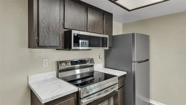 a kitchen with stainless steel appliances granite countertop a stove microwave and refrigerator
