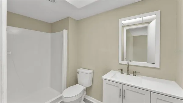 a bathroom with a toilet sink vanity and mirror