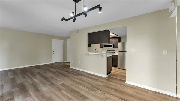 a view of a livingroom with a flat screen tv wooden floor and a ceiling fan