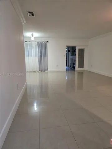 en empty room with windows and cabinet