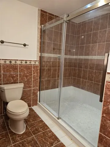 a bathroom with a toilet and a shower