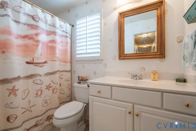 a bathroom with a toilet sink vanity and mirror