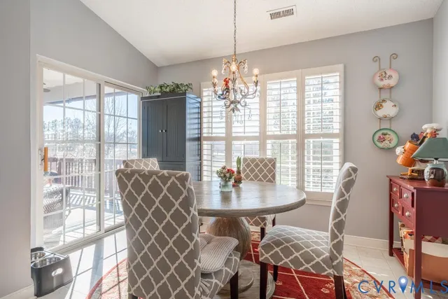 a view of a dining room with furniture and chandelier