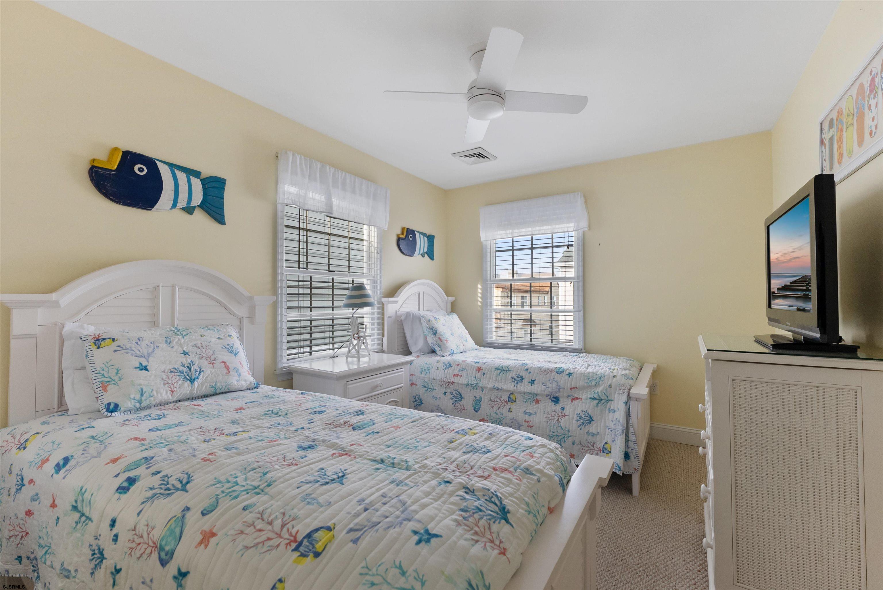 4930 Asbury Avenue, Unit 2 Ocean City, NJ 08226 - Photo 17 of 25 a bedroom with a bed and a flat tv screen on dresser